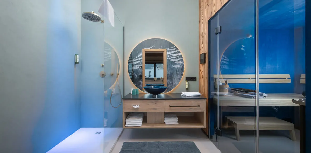 Großes, modernes Badezimmer mit vielen Glaselementen und Sauna