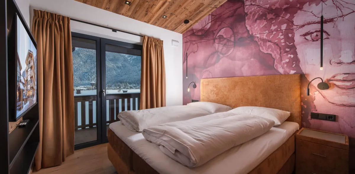 Modernes Schlafzimmer mit großzügigem Doppelbett vor roter Designtapete