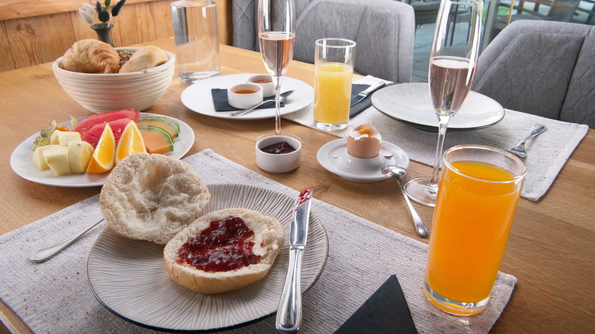 Nahaufnahme gedeckter Frühstückstisch mit Obst, Gebäck und Getränken
